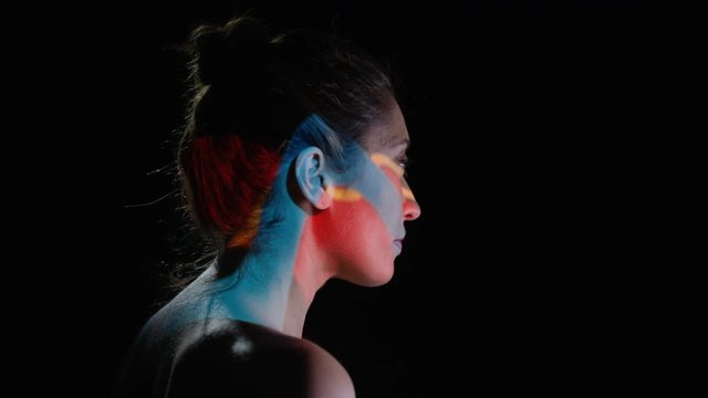  Colorful patterns of light projected onto the face & body of attractive model