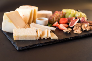 Cheese plate with variety of appetizers on table