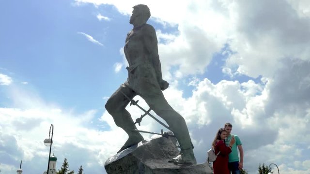 Russia, Kazan, 15 june 2017. Young couple taking a selfie on a mobile phone on a a statue on background. 3840x2160