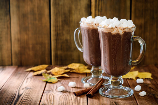 Hot chocolate with marshmallow in glass cups on wooden background