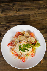 Caesar salad with croutons, cheese, eggs, tomatoes and grilled chicken on wooden tabel. with copy space. top view