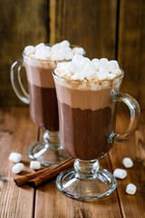 Hot chocolate with marshmallow in glass cups on wooden background