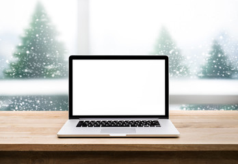 Computer,laptop with blank screen on snowfall in white.christmas winter backgrounds