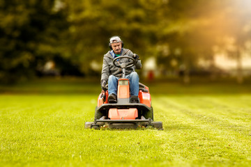 the lawn mower drives through a green meadow