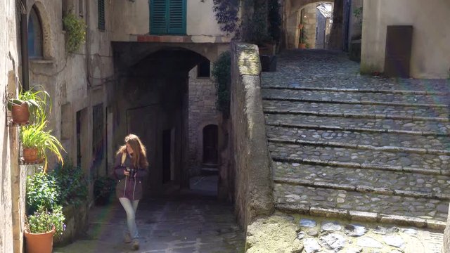 girl taking a picture of tuscanian town streets