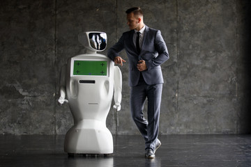 A stylish man communicates with a robot. Cybernetic system today. Modern Robotic Technologies....