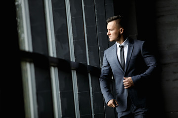 Portrait of stylish male dressed in a suit over grey background