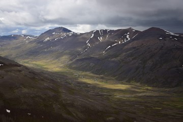 Sonne und Wolken in isländischer Berglandschaft