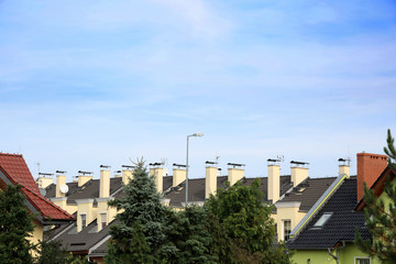 Dachy i szereg kominów na apartamentowcu w Opolu.