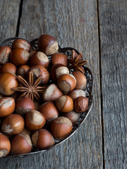 Hazelnuts in openwork plate on teriann background rustic