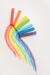 Rainbow gradient made of pastel crayon chalks over the colorful traces