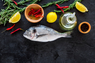 Preparing fresh sea fish. Black background top view copyspace