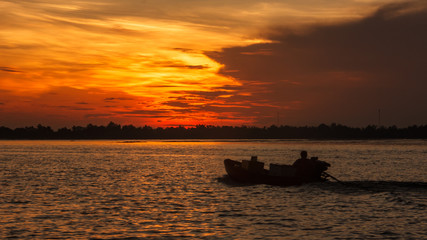 Obraz premium Boat Riding Silhouette on the morning sunrise in Hau River, a distributary of the Mekong river, Can Tho, Vietnam, Indochina, Asia.