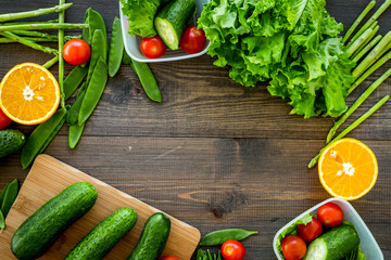 Healthy meal in containers. Salad with tomato and cucumber in cotainers on wooden background top view copyspace