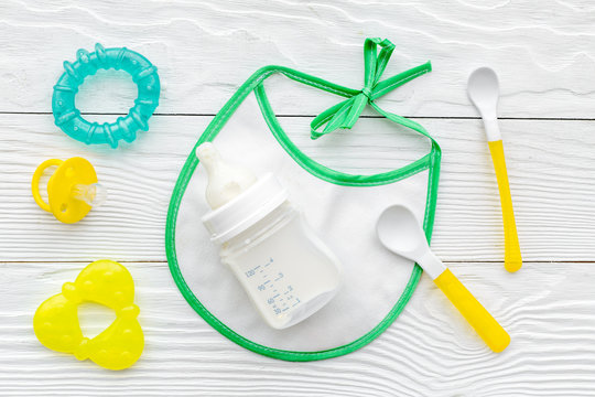 children feeding with breastmilk or infant formula powdered baby milk and toys on wooden background top view