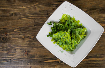 Green ravioli with spinach on a wooden background with copy space. top view