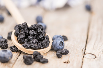 Dried Blueberries on wooden background; selective focus