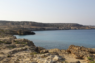 Fototapeta na wymiar The coast with its rocky beach and clear water