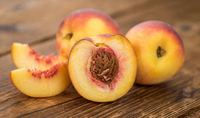 Fototapeta na wymiar Portion of Fresh Peaches on wooden background, selective focus