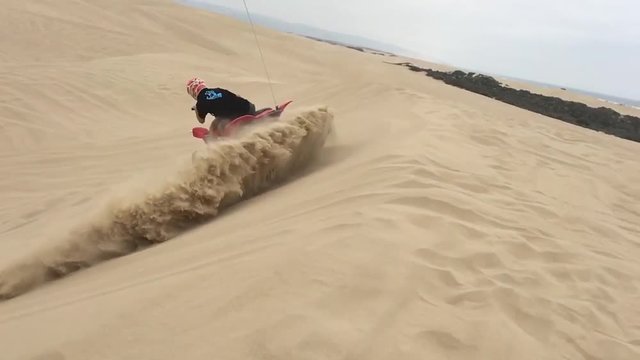 Ragazzo con quad su dune di sabbia, slowmotion