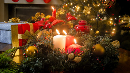 Fototapeta na wymiar Beautiful Christmas background with burning Christmas candles on Advent wreath at living room