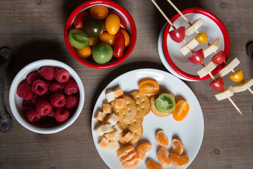 Snack idea - berry, tomato, crackers and cheese in enameled bowls