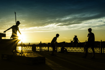 ASTRAKHAN (RUSSIA) AUGUST 2017 - Young boy playing with skate on sunset silhouette