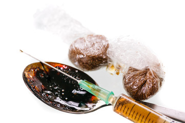 Two wraps of brown drugs, probably heroin, with a dirty spoon and a prepared syringe