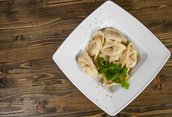 Meat dumplings - russian pelmeni, ravioli with meat on a wooden background. with copy space. top view