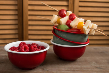 Snack idea, crackers, cheese, tomatoes, mandarin in enameled bowls 