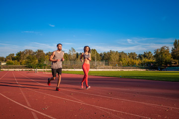 Couple running on track at the stadium