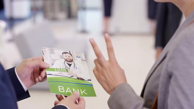  Friendly bank workers talking to customer & offering advice about a loan