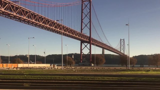 Famous Tagus Bridge In Lisbon, Vehicle Shot. POV Train ride through city of Lisbon on a beautiful sunny day
