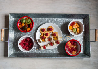 Snack idea, crackers, cheese, tomatoes, mandarin in enameled bowls 