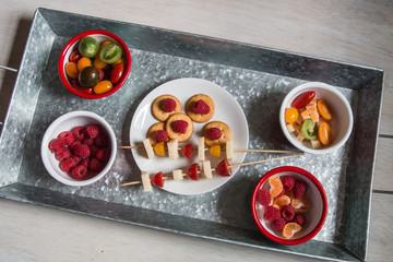 Snack idea, crackers, cheese, tomatoes, mandarin in enameled bowls 
