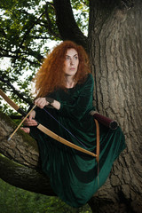 Red haired girl shoots from the bow
