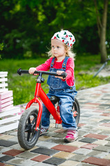 little girl riding her red bike