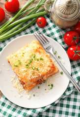 Plate with tasty lasagna on table