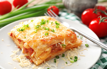 Plate with tasty lasagna on table