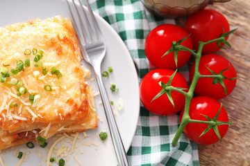 Plate with tasty lasagna on table