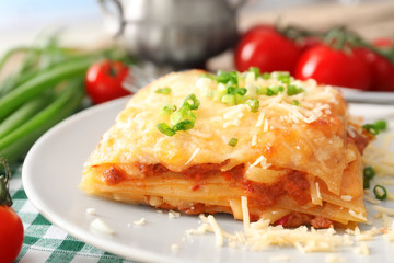 Plate with tasty lasagna on table