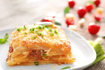 Plate with tasty lasagna on table