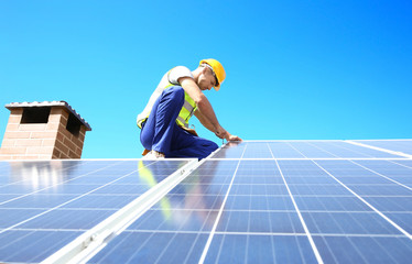 Worker installing solar panels outdoors