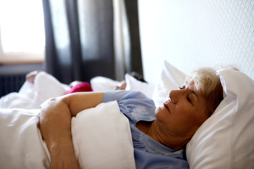 Old couple sleeping on bed