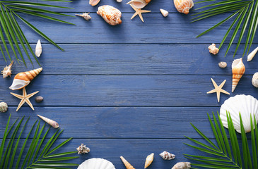 Composition with shells and leaves on wooden background. Summer vacation concept