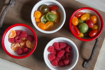 Snack idea, crackers, cheese, tomatoes, mandarin in enameled bowls 