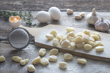 Uncooked potato gnocchi with ingredients