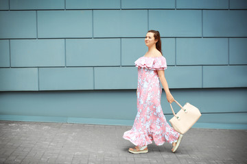 Beautiful overweight woman in pink ruffled dress walking on city street