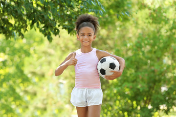 Cute African American girl with ball in park