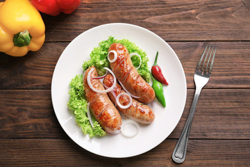 Grilled sausages served with vegetables on white plate